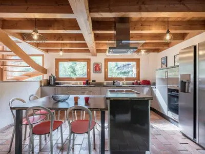 a kitchen with a wooden ceiling and a table and chairs at Chalet CLADIE - Private Jacuzzi & Sauna - View of Mont Blanc range - By Cozee Rentals in Les Houches