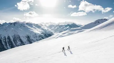 two people skiing down a snow covered mountain at Chalet CLADIE - Private Jacuzzi & Sauna - View of Mont Blanc range - By Cozee Rentals in Les Houches