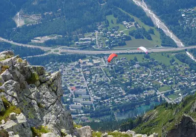 two kites flying over a city on a mountain at Chalet CLADIE - Private Jacuzzi & Sauna - View of Mont Blanc range - By Cozee Rentals in Les Houches
