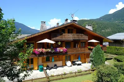 a large wooden house with tables and chairs at Appartement Les Clarines in Les Houches