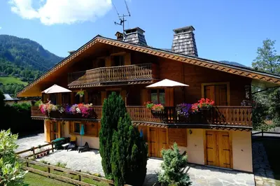 a house with a balcony and flowers on it at Appartement Les Clarines in Les Houches