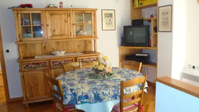 a dining room with a table and a tv at Appartement Les Clarines in Les Houches