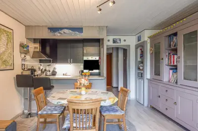 a kitchen with a table and chairs in a room at Chamonix centre, 51m2, vue Mt Blanc, 2 à 6 pers, 2 balcons in Chamonix-Mont-Blanc