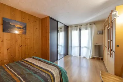 a bedroom with wooden walls and a bed and a window at Chamonix centre, 51m2, vue Mt Blanc, 2 à 6 pers, 2 balcons in Chamonix-Mont-Blanc