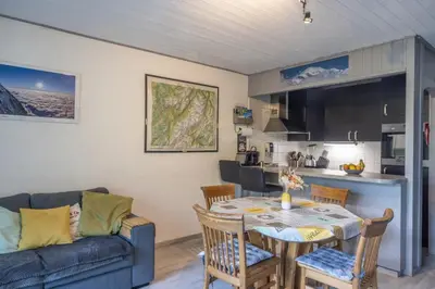 a kitchen and living room with a table and a couch at Chamonix centre, 51m2, vue Mt Blanc, 2 à 6 pers, 2 balcons in Chamonix-Mont-Blanc