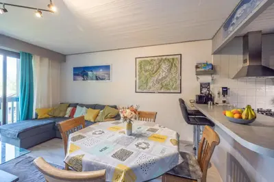 a kitchen and living room with a table and a couch at Chamonix centre, 51m2, vue Mt Blanc, 2 à 6 pers, 2 balcons in Chamonix-Mont-Blanc