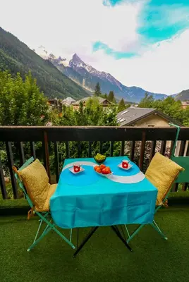 a blue table and chairs on a balcony with mountains at Chamonix centre, 51m2, vue Mt Blanc, 2 à 6 pers, 2 balcons in Chamonix-Mont-Blanc