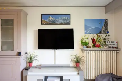 a living room with a flat screen tv on a wall at Chamonix centre, 51m2, vue Mt Blanc, 2 à 6 pers, 2 balcons in Chamonix-Mont-Blanc