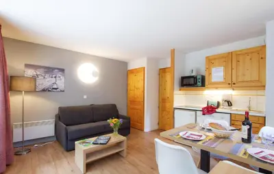 a small living room with a table and a couch at Résidence Odalys Le Buet in Morillon