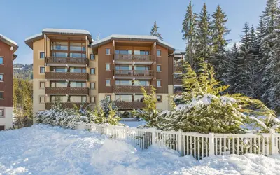 a building in the snow with a fence at Résidence Odalys Le Buet in Morillon