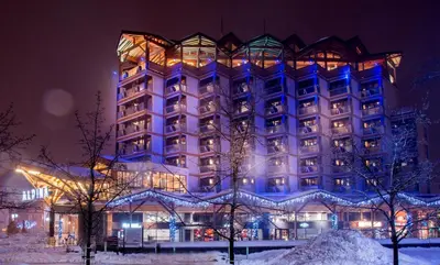 a large building in the snow at night at Alpina Eclectic Hotel in Chamonix-Mont-Blanc