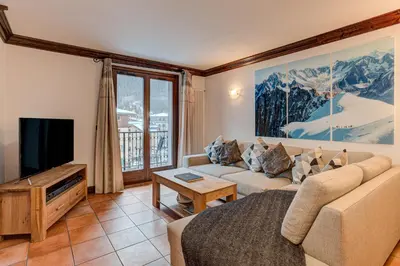 a living room with a couch and a tv at APARTMENT KITSON - Alpes Travel - Chamonix - Sleeps 6 in Chamonix-Mont-Blanc