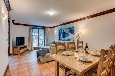 a dining room with a table and a couch at APARTMENT KITSON - Alpes Travel - Chamonix - Sleeps 6 in Chamonix-Mont-Blanc