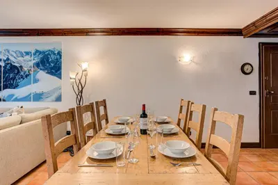 a dining room with a table and chairs and a couch at APARTMENT KITSON - Alpes Travel - Chamonix - Sleeps 6 in Chamonix-Mont-Blanc