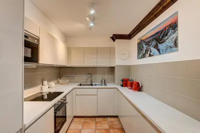 a kitchen with white cabinets and a sink at APARTMENT KITSON - Alpes Travel - Chamonix - Sleeps 6 in Chamonix-Mont-Blanc