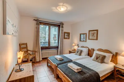 a bedroom with a large bed and a window at APARTMENT KITSON - Alpes Travel - Chamonix - Sleeps 6 in Chamonix-Mont-Blanc