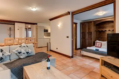 a living room with a couch and a television at APARTMENT KITSON - Alpes Travel - Chamonix - Sleeps 6 in Chamonix-Mont-Blanc
