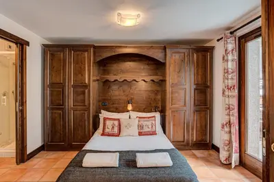 a bedroom with a large bed with a wooden headboard at APARTMENT KITSON - Alpes Travel - Chamonix - Sleeps 6 in Chamonix-Mont-Blanc