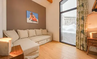 a living room with a couch and a large window at Maison Des Praz Chamonix in Chamonix-Mont-Blanc