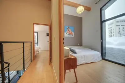 a bedroom with a bed and a sliding glass door at Maison Des Praz Chamonix in Chamonix-Mont-Blanc
