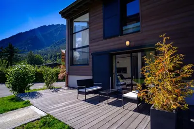 a house with a deck with a view of mountains at Maison Des Praz Chamonix in Chamonix-Mont-Blanc
