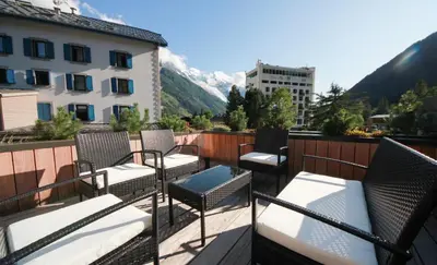 a balcony with chairs and a view of mountains at Maison Des Praz Chamonix in Chamonix-Mont-Blanc