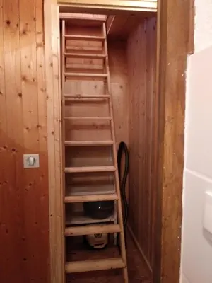 a book shelf in a room with a ladder at Le Si-près Pied des pistes in Les Carroz d'Araches