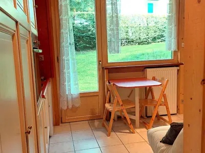 a small table and chairs in a room with a window at Studio rénové 16m2, terrasse, animaux admis, parking, près télécabine Brévent - FR-1-517-3 in Chamonix-Mont-Blanc