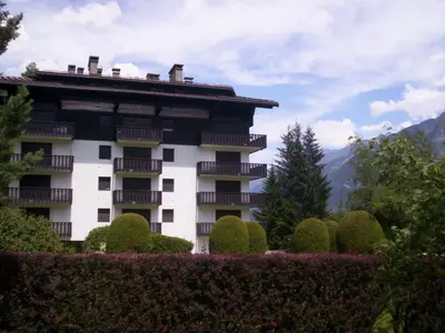 a building with a bunch of bushes in front of it at Studio rénové 16m2, terrasse, animaux admis, parking, près télécabine Brévent - FR-1-517-3 in Chamonix-Mont-Blanc