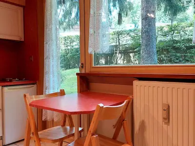 a table and chairs in a kitchen with a window at Studio rénové 16m2, terrasse, animaux admis, parking, près télécabine Brévent - FR-1-517-3 in Chamonix-Mont-Blanc