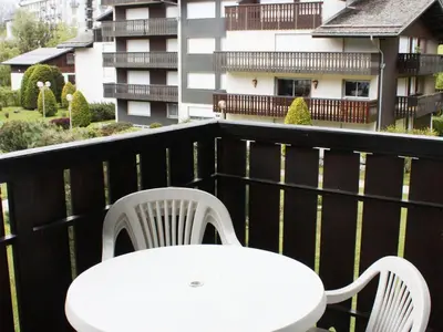 a white table and chairs on a balcony with a building at Appartement à Chamonix avec Balcon, Animaux Acceptés et Parking - FR-1-517-12 in Chamonix-Mont-Blanc