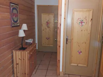 a hallway with two doors and a lamp on a dresser at Beau 3 pièces spacieux avec parking proche du Mont Blanc - 6 pers. - FR-1-517-15 in Chamonix-Mont-Blanc