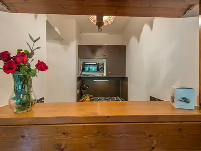 a vase of roses sitting on top of a kitchen counter at Charmant 2 Pièces Chamonix, 4 Pers, Animaux Ok, Parking - FR-1-517-18 in Chamonix-Mont-Blanc