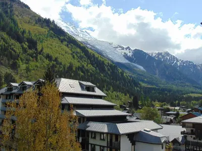 a building in front of a mountain with snow at Charmant 2 Pièces Chamonix, 4 Pers, Animaux Ok, Parking - FR-1-517-18 in Chamonix-Mont-Blanc