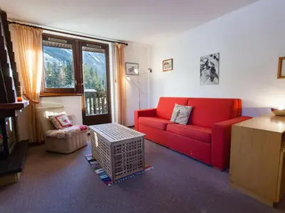 a living room with a red couch and a window at 2 Pièces Vue Mont Blanc avec Balcon - Chamonix, Animaux acceptés - FR-1-517-19 in Chamonix-Mont-Blanc