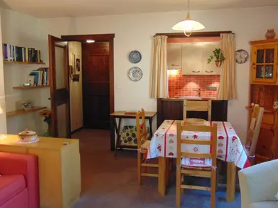 a living room with a table and a kitchen at 2 Pièces Vue Mont Blanc avec Balcon - Chamonix, Animaux acceptés - FR-1-517-19 in Chamonix-Mont-Blanc