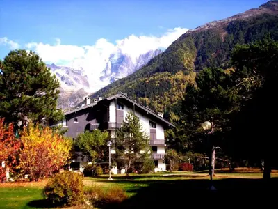 a building in front of a mountain with trees at 2 Pièces Vue Mont Blanc avec Balcon - Chamonix, Animaux acceptés - FR-1-517-19 in Chamonix-Mont-Blanc