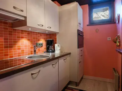 a small kitchen with a sink and orange tiles at 2 Pièces Vue Mont Blanc avec Balcon - Chamonix, Animaux acceptés - FR-1-517-19 in Chamonix-Mont-Blanc