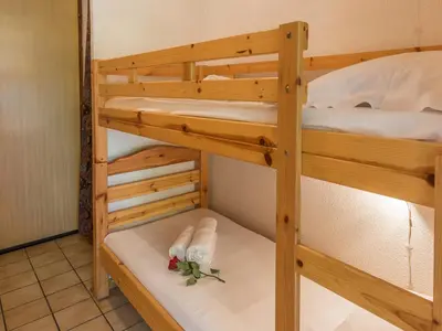 a bunk bed with a pair of white shoes in a bunk room at Studio cosy à Chamonix - Animaux admis, parking privé - FR-1-517-21 in Chamonix-Mont-Blanc