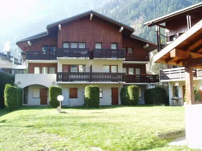a large building with a grass yard in front of it at Studio cosy à Chamonix - Animaux admis, parking privé - FR-1-517-21 in Chamonix-Mont-Blanc