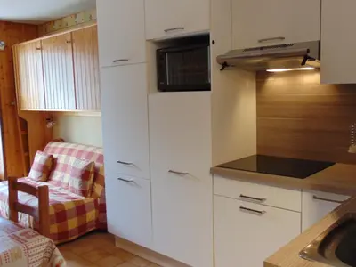 a small kitchen with white cabinets and a sink at Studio convivial en zone piétonne avec animaux admis, balcon - Chamonix - FR-1-517-23 in Chamonix-Mont-Blanc