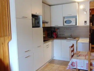 a small kitchen with white cabinets and a microwave at Studio convivial en zone piétonne avec animaux admis, balcon - Chamonix - FR-1-517-23 in Chamonix-Mont-Blanc