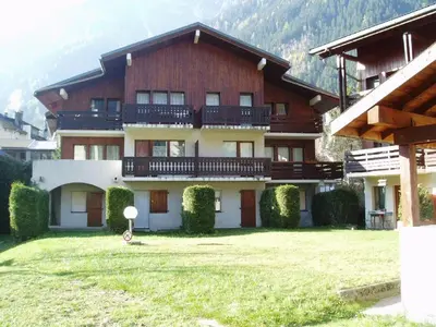 a large building with a grass yard in front of it at 2 Pièces à Chamonix, Vue Mont-Blanc, Animaux admis, Parking - FR-1-517-26 in Chamonix-Mont-Blanc