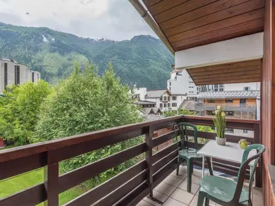 a balcony with a table and chairs and mountains at 2 Pièces à Chamonix, Vue Mont-Blanc, Animaux admis, Parking - FR-1-517-26 in Chamonix-Mont-Blanc