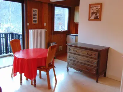 a kitchen with a red table and chairs and a dresser at Studio lumineux 3 pers, animaux admis, parking - FR-1-517-27 in Chamonix-Mont-Blanc