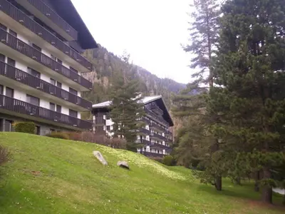 a building on a hill next to a green field at Studio lumineux 3 pers, animaux admis, parking - FR-1-517-27 in Chamonix-Mont-Blanc