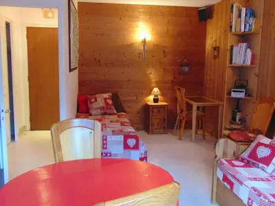 a living room with a red table and chairs and a room with a couch at Studio lumineux 3 pers, animaux admis, parking - FR-1-517-27 in Chamonix-Mont-Blanc