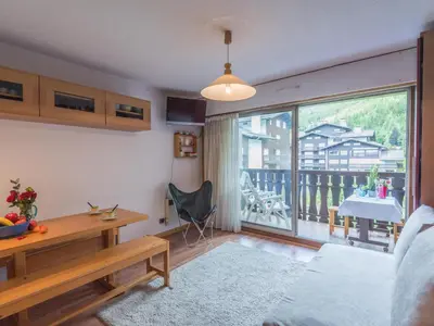 a living room with a desk and a large window at Studio lumineux proche des pistes, animaux admis - FR-1-517-32 in Chamonix-Mont-Blanc