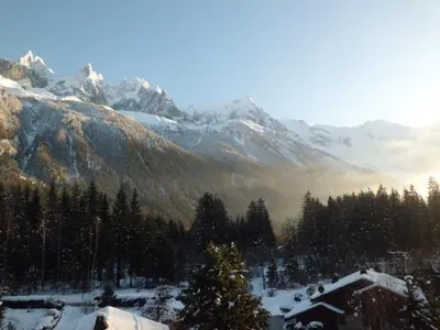 a snow covered mountain range with a house and trees at Studio Charmant avec Vue Mont Blanc, Parking et Animaux Admis - FR-1-517-35 in Chamonix-Mont-Blanc