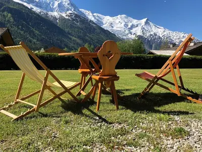 two chairs and a table with mountains in the background at Charmant 3 pièces avec terrasse, parking, 6 couchages - Chamonix - FR-1-517-38 in Chamonix-Mont-Blanc